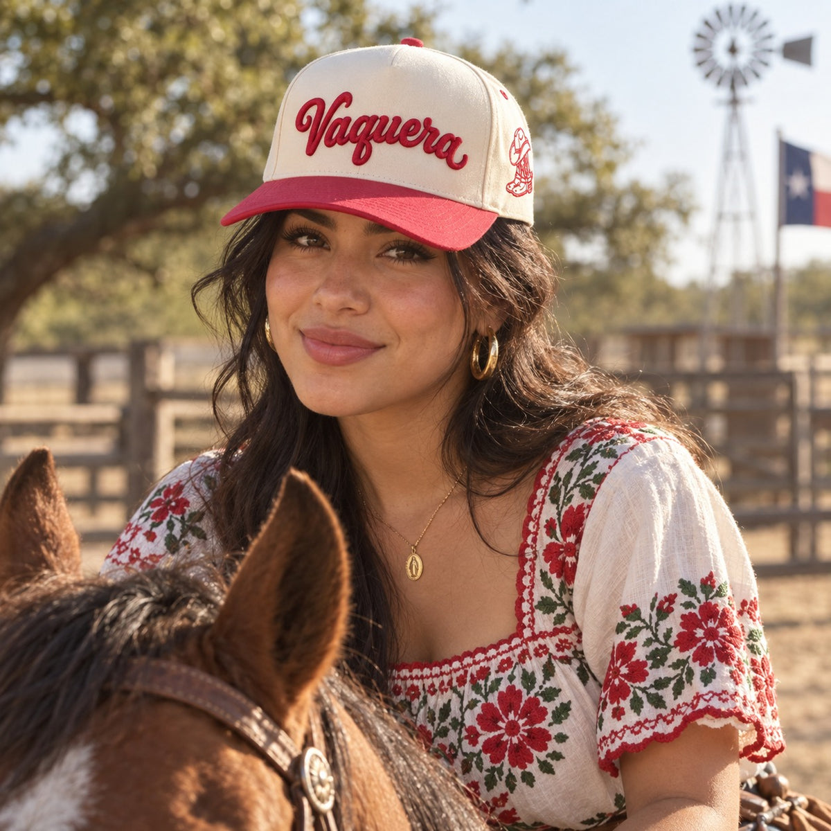 Woman on horseback at a Texas ranch wearing the Vaquera trucker hat in Natural / Red Bill