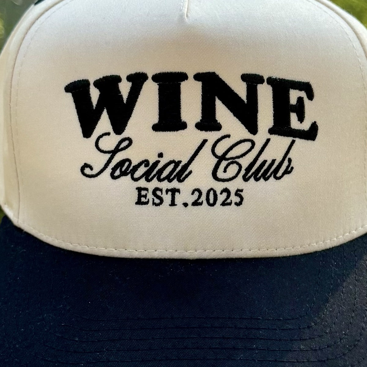 Close-up of the black embroidered lettering on the front of the Wine Social Club trucker hat