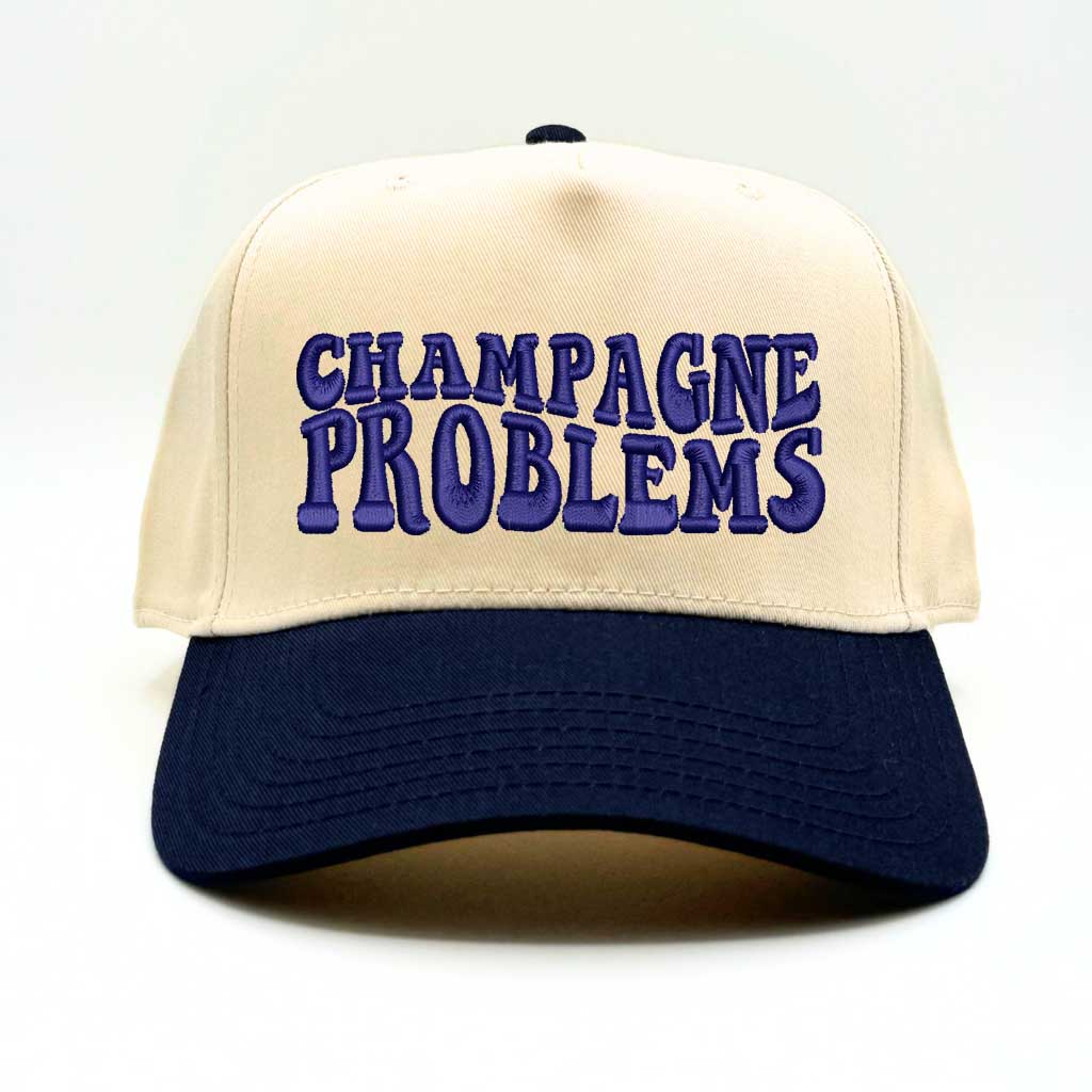 Natural color baseball hat with navy bill and the phrase champagne problems in navy embroidery-DSY Lifestyle