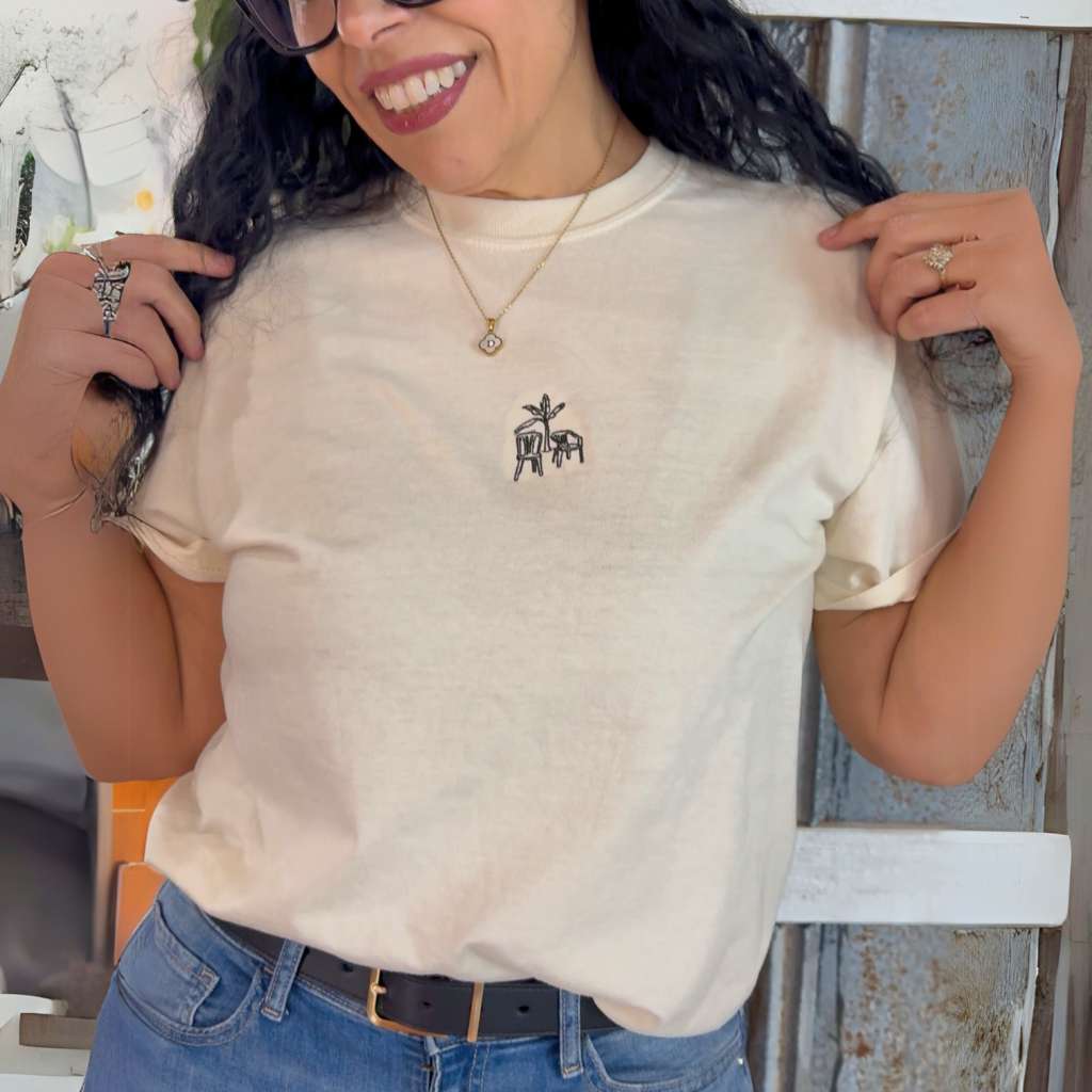 Ivory Comfort Colors washed oversized t-shirt by DSY Lifestyle featuring a minimalist white DTMF embroidery of a platano tree and two chairs on the front.