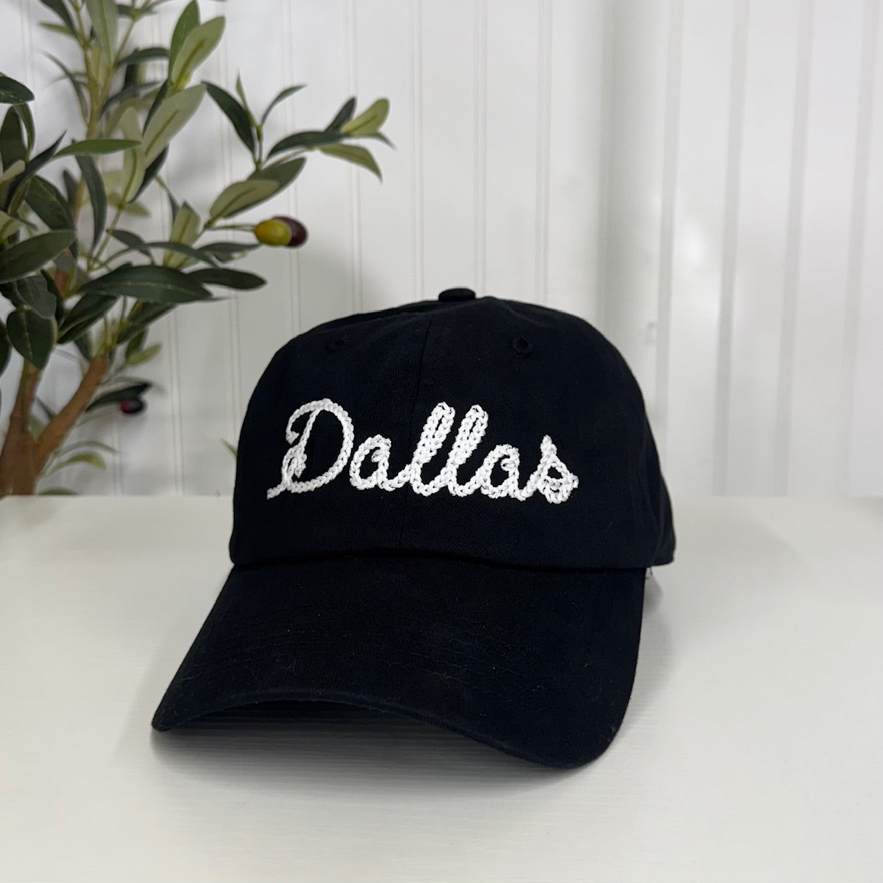 Black baseball hat with "Dallas" embroidered in chain stitch cursive, offering a classic and stylish way to rep your city - DSY Lifestyle