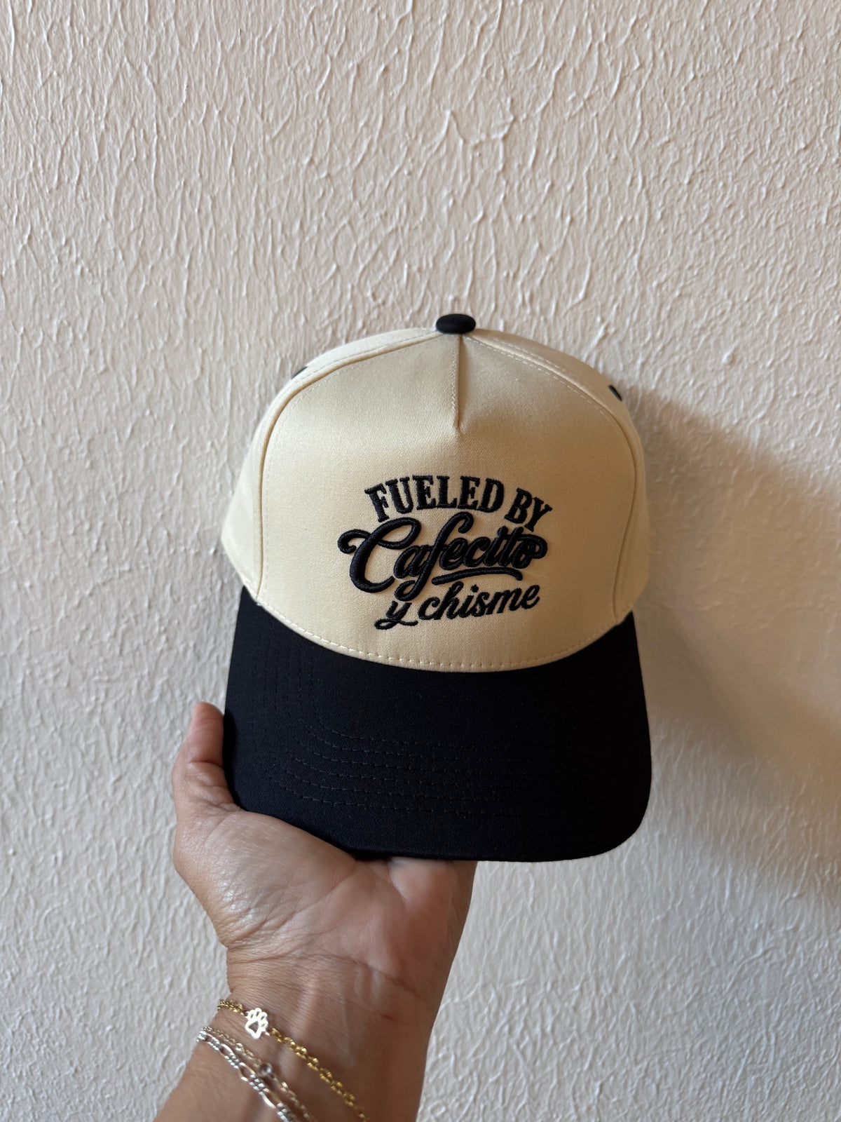 Fueled by Cafecito y Chisme embroidered two-tone trucker hat on a white background