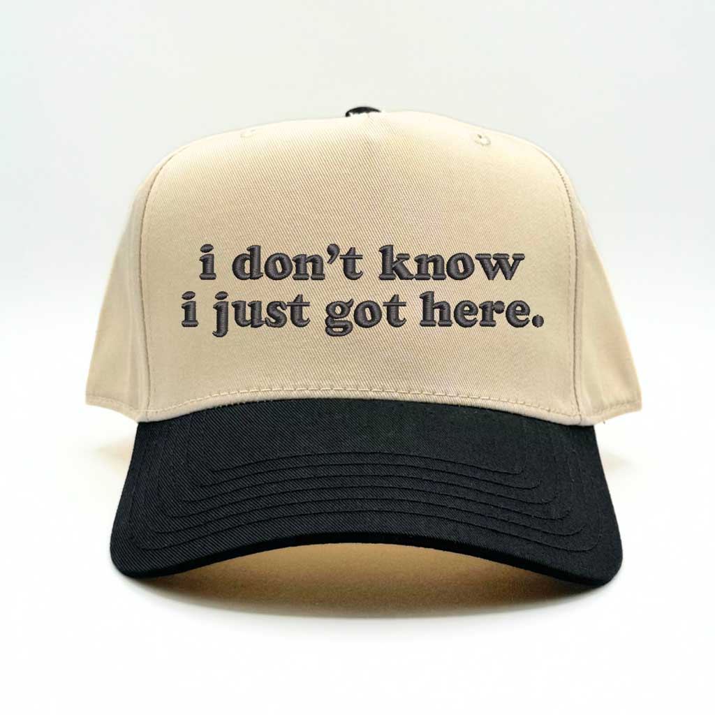 Natural baseball hat with black colored bill and the phrase i don&