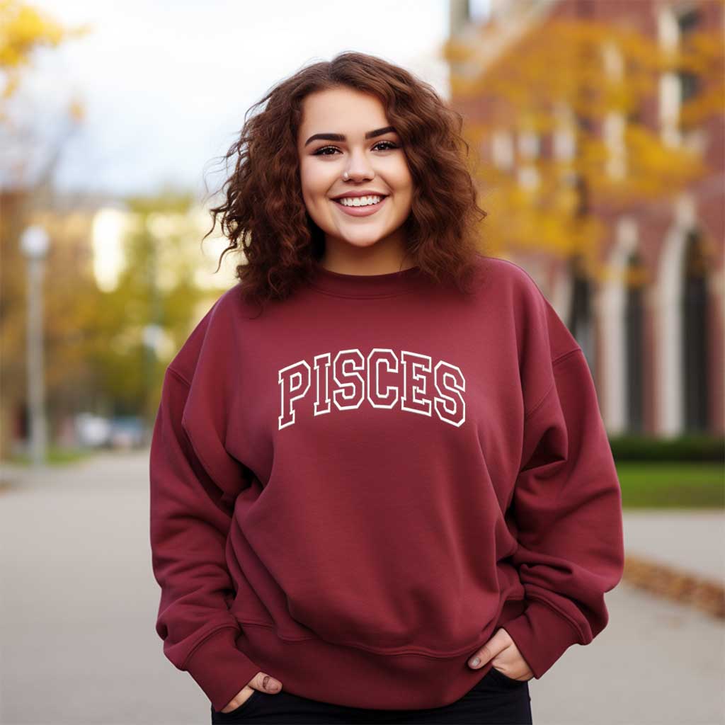 Woman wearing a embroidered maroon sweatshirt with PISCES text outdoors - DSY Lifestyle