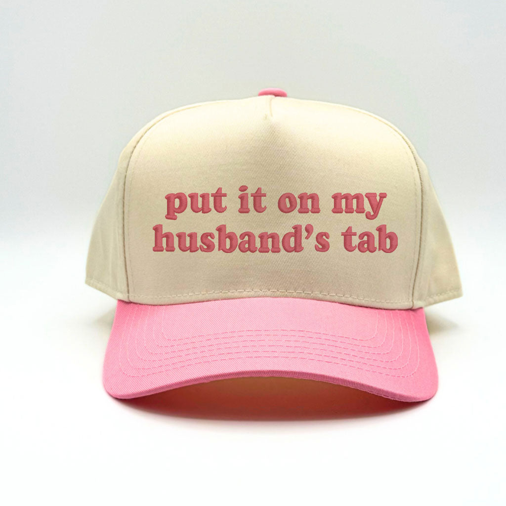 Flat lay of the Pink Sorry About My Husband baseball cap with casual accessories