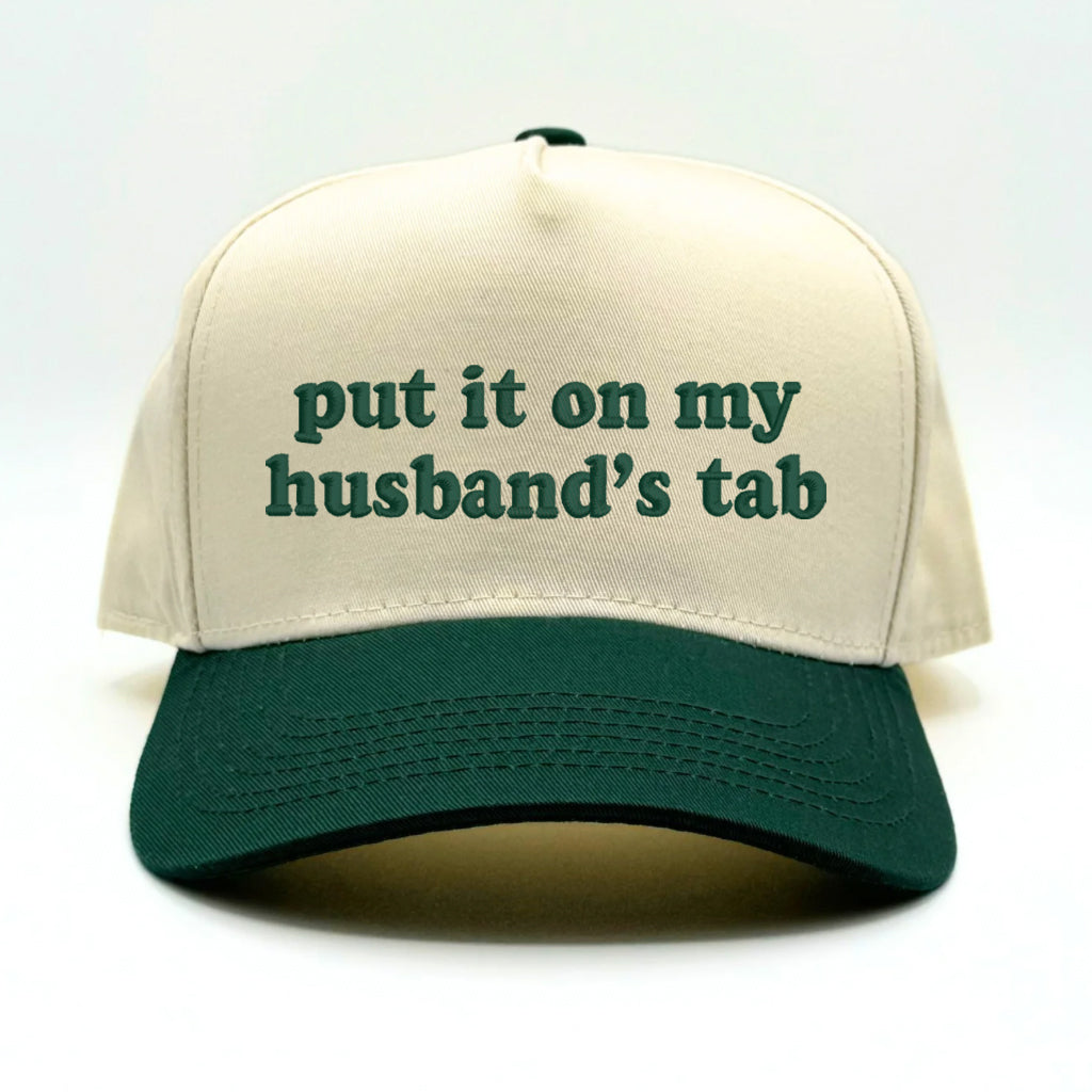 Flat lay of the Forest Green Sorry About My Husband baseball cap with casual accessories