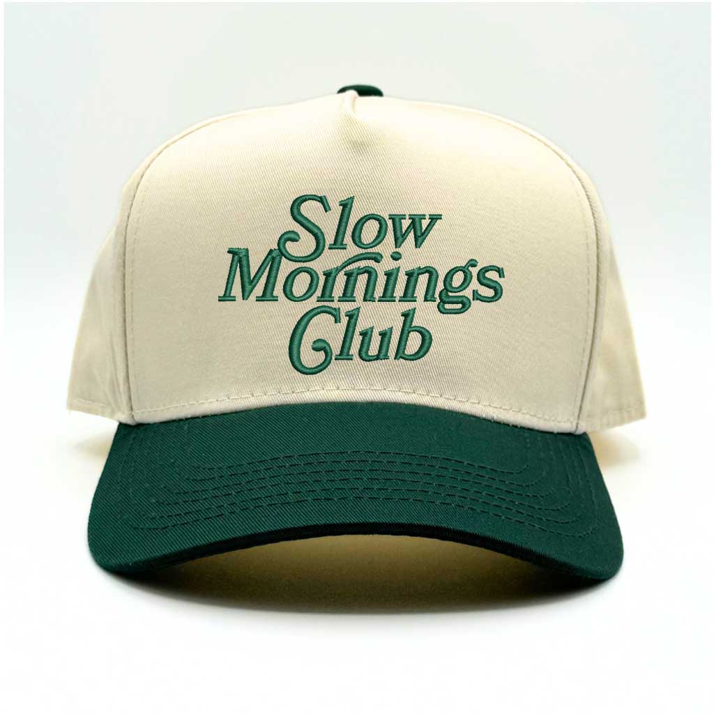 Beige and green 5-panel baseball hat with "Slow Mornings Club" embroidered by DSY Lifestyle in green on the front.