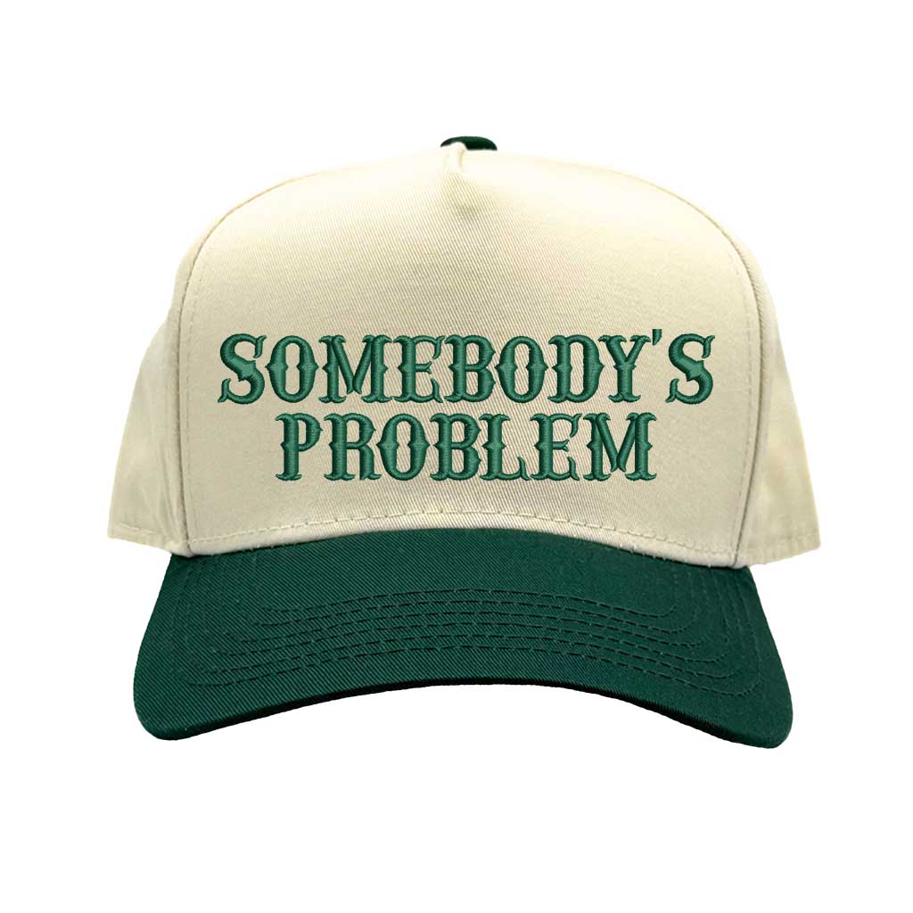 Natural Forest Green two-tone 5 panel Somebody’s Problem embroidered dad hat with white front panel, beige brim, bold black text, and adjustable strap. – DSY Lifestyle.