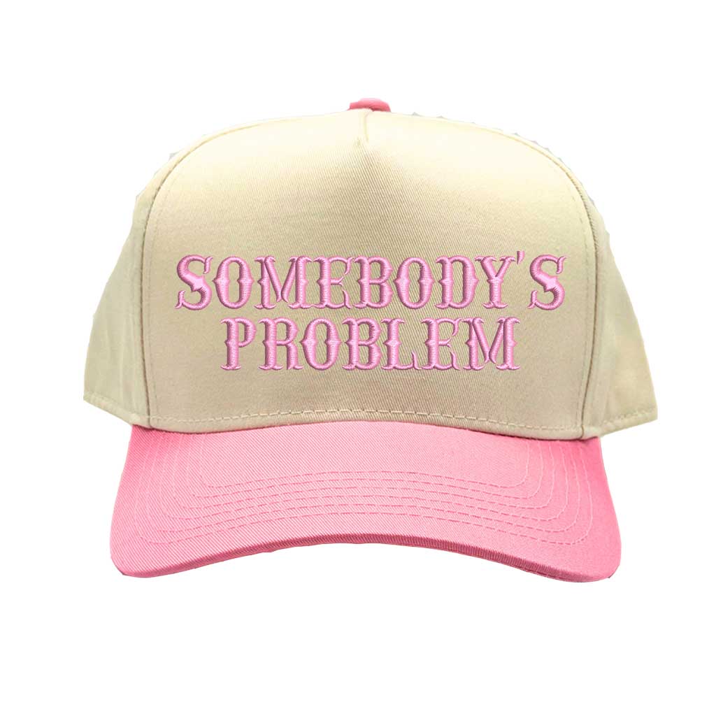 Natural Light Pink two-tone 5 panel Somebody’s Problem embroidered dad hat with white front panel, beige brim, bold black text, and adjustable strap. – DSY Lifestyle.