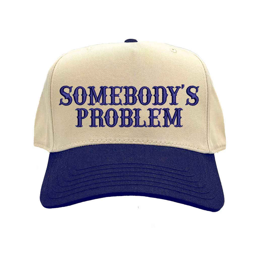 Natural Navy Blue two-tone 5 panel Somebody’s Problem embroidered dad hat with white front panel, beige brim, bold black text, and adjustable strap. – DSY Lifestyle.