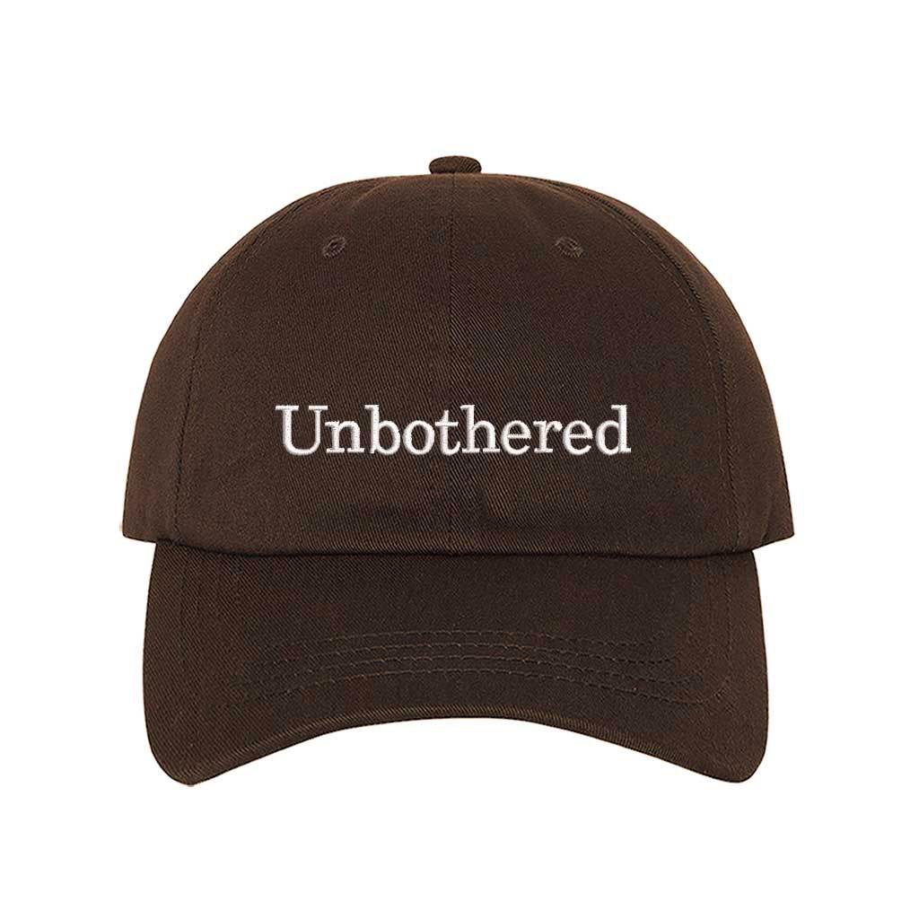 Brown Front view of a classic baseball hat featuring "Unbothered" in high-density script embroidery on the center crown. - DSY Lifestyle