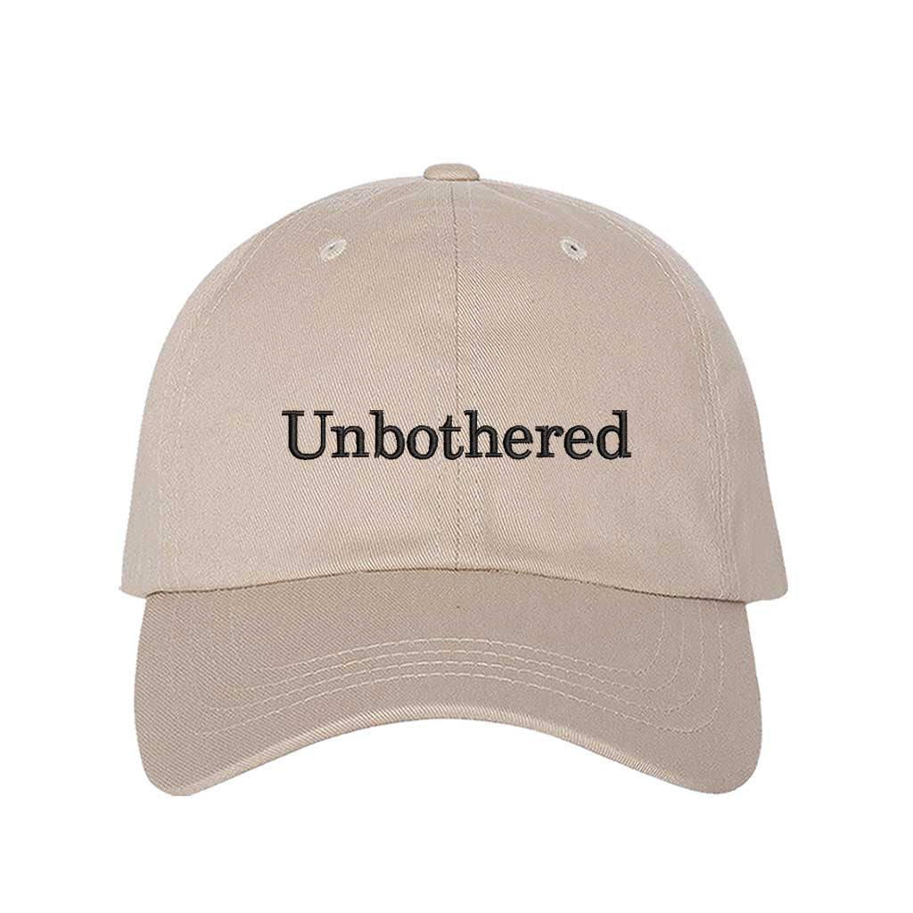 Stone Front view of a classic baseball hat featuring "Unbothered" in high-density black script embroidery on the center crown. - DSY Lifestyle