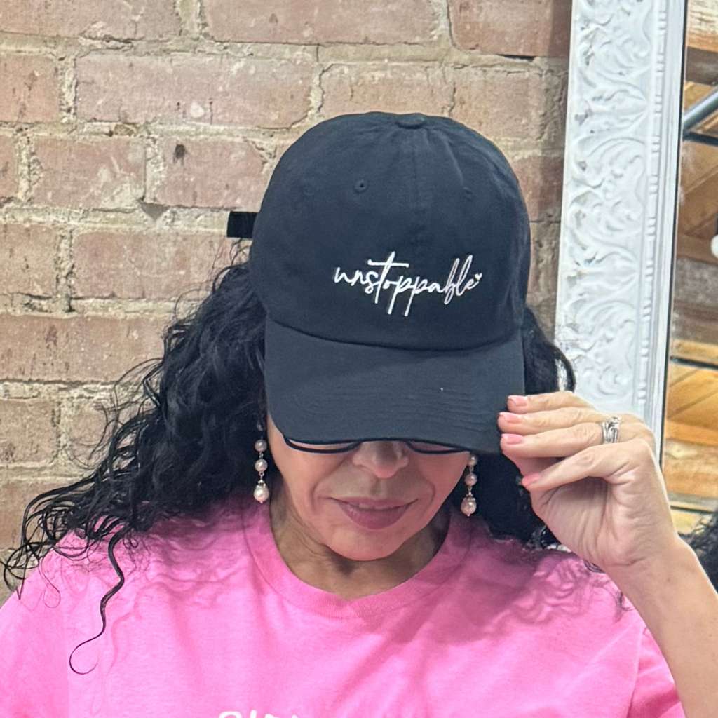 Woman wearing an embroidered Unstoppable Black baseball hat