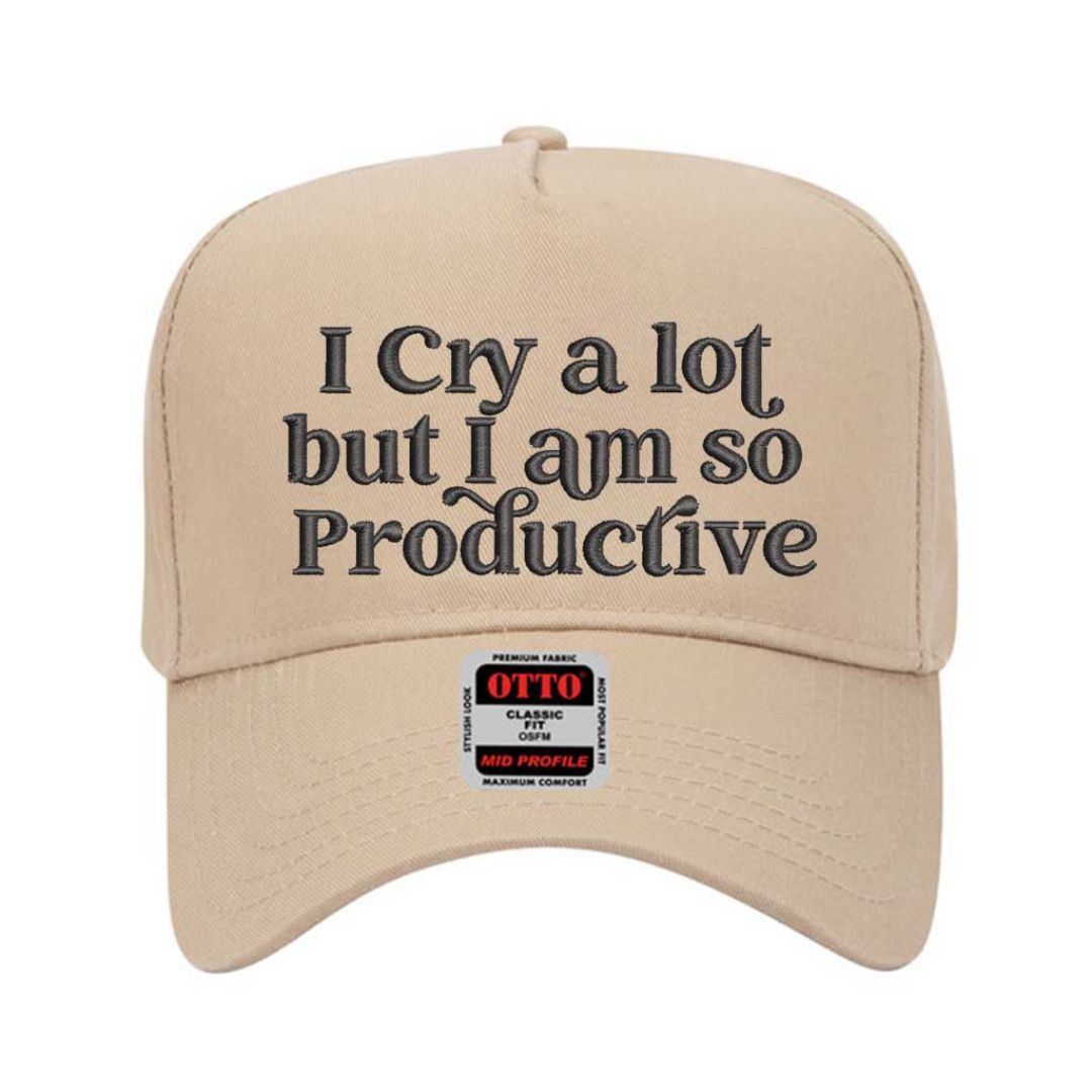 Solid Khaki Two-tone embroidered baseball hat with “I Cry A Lot But I’m So Productive” stitched in bold lettering, styled on a casual outfit for emotional but driven energy. - DSY Lifestyle