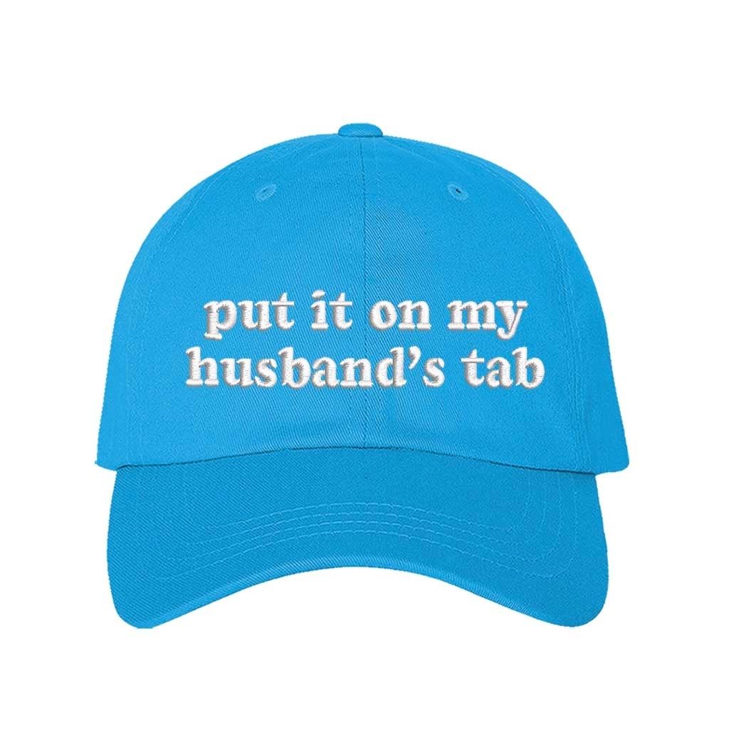 Aqua Put It on My Husband’s Tab Embroidered Baseball Hat in soft cotton with curved brim and adjustable back strap, perfect for vacations and girls’ nights. DSY Lifestyle.