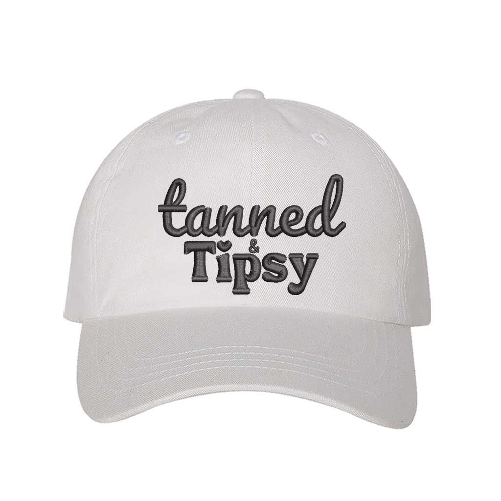 White Tanned and Tipsy Embroidered Baseball Hat in classic cotton with pre-curved brim and hook and loop closure, perfect for beach days and summer drinks. DSY Lifestyle.