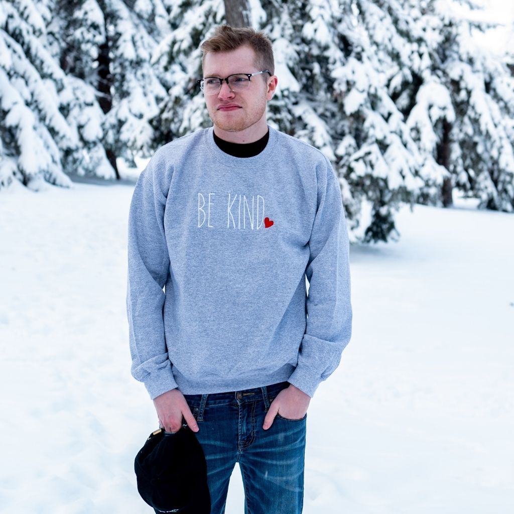 Male wearing heather gray Sweatshirt embroidered with Be Kind in the front - DSY Lifestyle