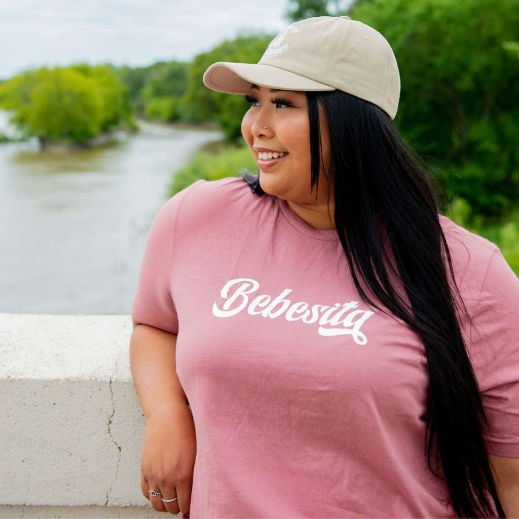 Female wearing stone color baseball hat and a Mauve T-shirt with Bebesita printed in the front- DSY Lifestyle