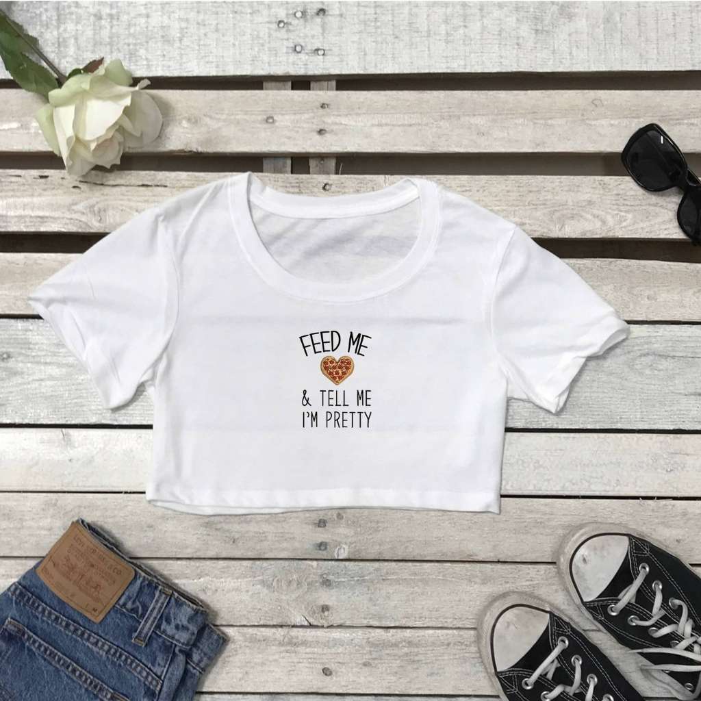 Flat lay of white underboob top with feed me and call me pretty printed on the front in white - DSY Lifestyle