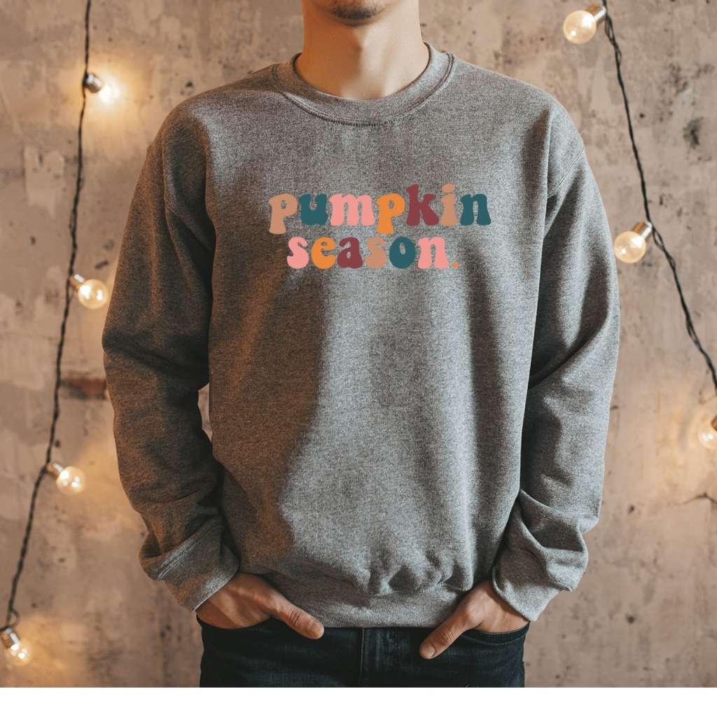 Male wearing a dark heather gray crewneck sweatshirt printed with pumpkin season in the front - DSY Lifestyle