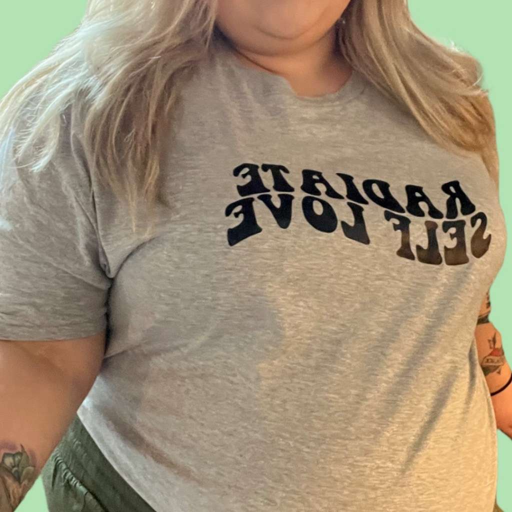 Female wearing a heather gray unisex tee with Radiate Self Love printed in black - DSY Lifestyle