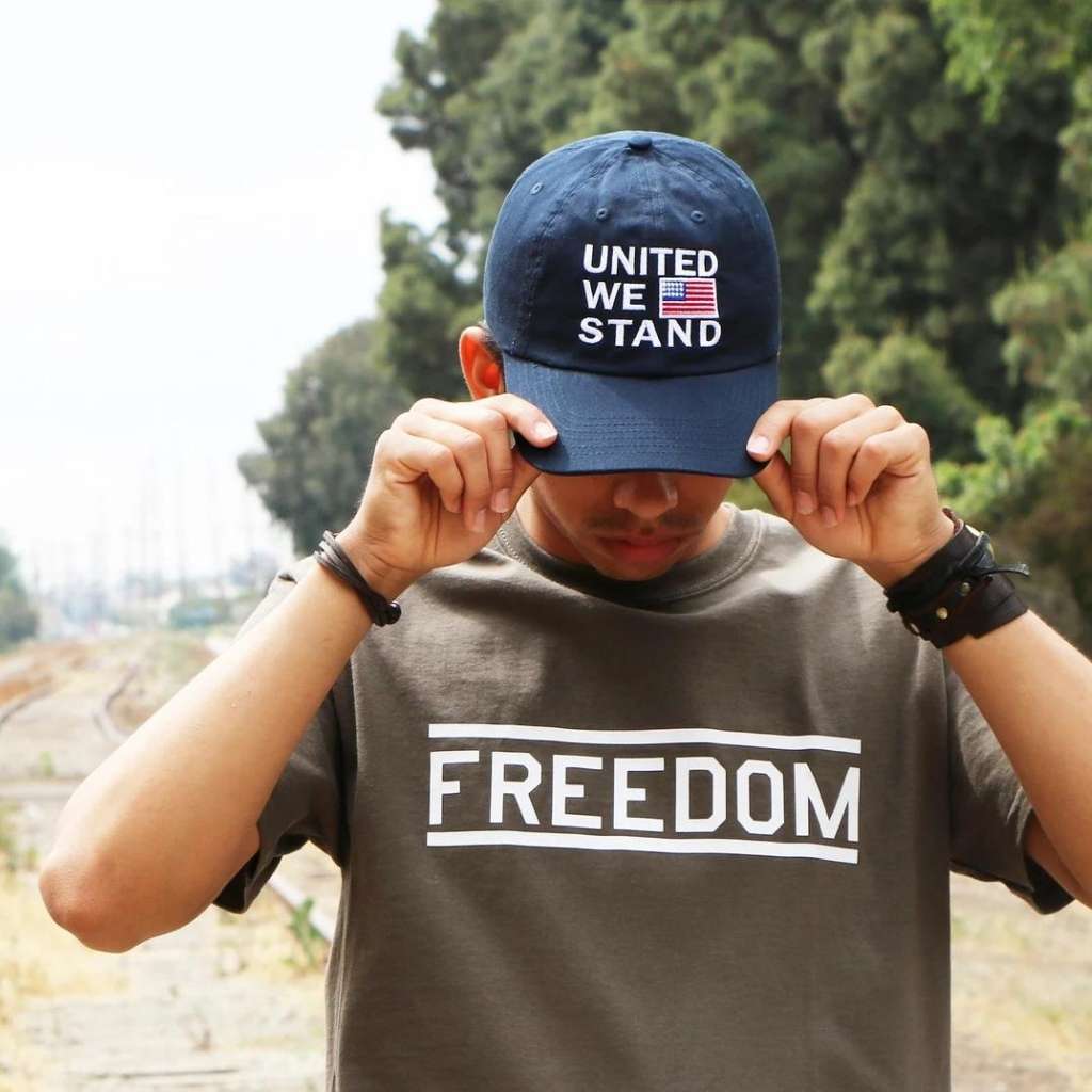 Male wearing a navy blue baseball cap embroidered with the USA Flag and United we stand - DSY Lifestyle