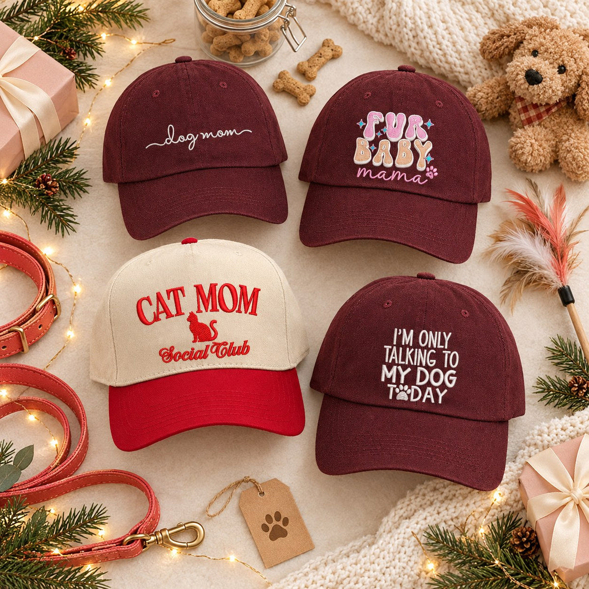 Flat lay of DSY embroidered pet lover hats: Dog Mom, Fur Baby Mama, Cat Mom Social Club and I'm Only Talking to My Dog Today with a leash, dog treats and a plush puppy