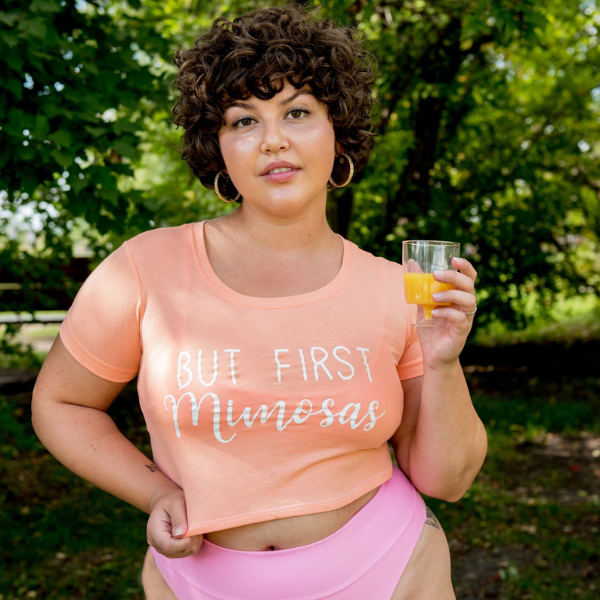 Underboob Crop Top and Crop Tops - Female wearing a Orange crop top with But first Mimosas printed in white - DSY Lifestyle