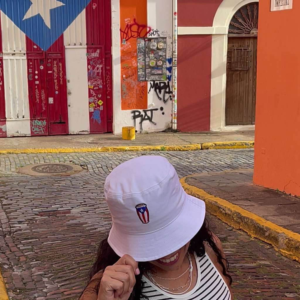 Female in Puerto Rico wearing a white bucket hat with a Conga that has the Puerto Rican Flag in it - DSY Lifestyle