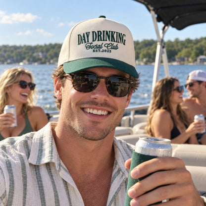 Man on a pontoon boat wearing the Day Drinking Social Club trucker hat in Natural / Forest Green Bill