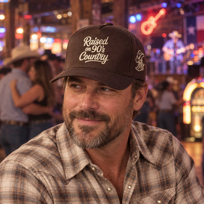 Man on a honky-tonk dance floor wearing the Raised on 90&