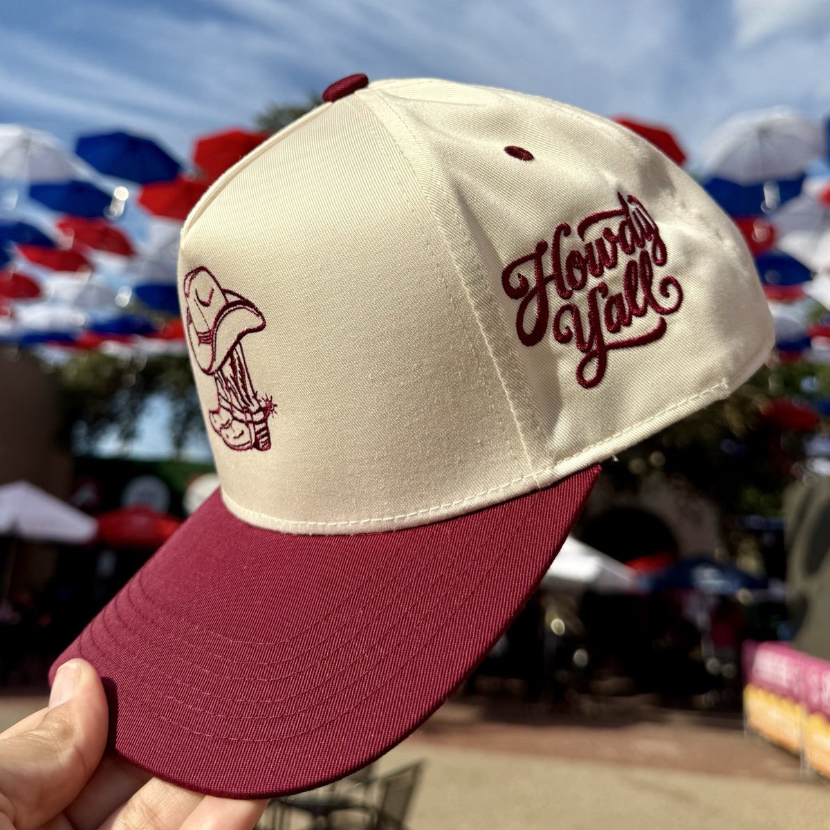 Side view of the Cowgirl Boots Howdy Yall trucker hat showing the maroon Howdy Yall script embroidery