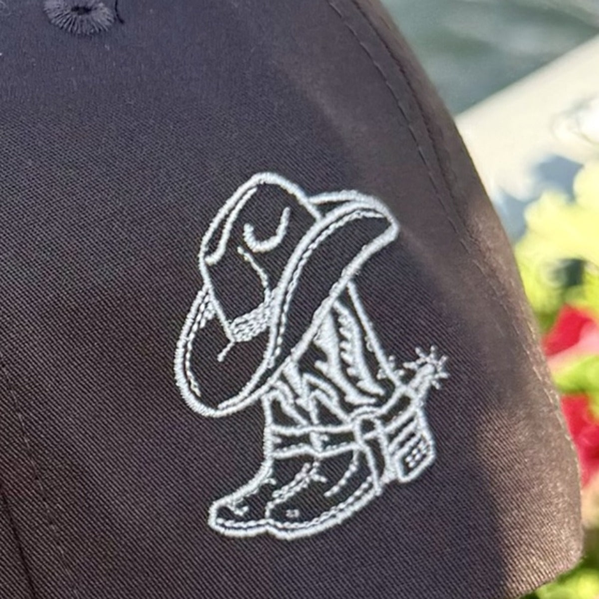 Close-up of the embroidered cowboy boot and hat on the side of the Raised on 90&