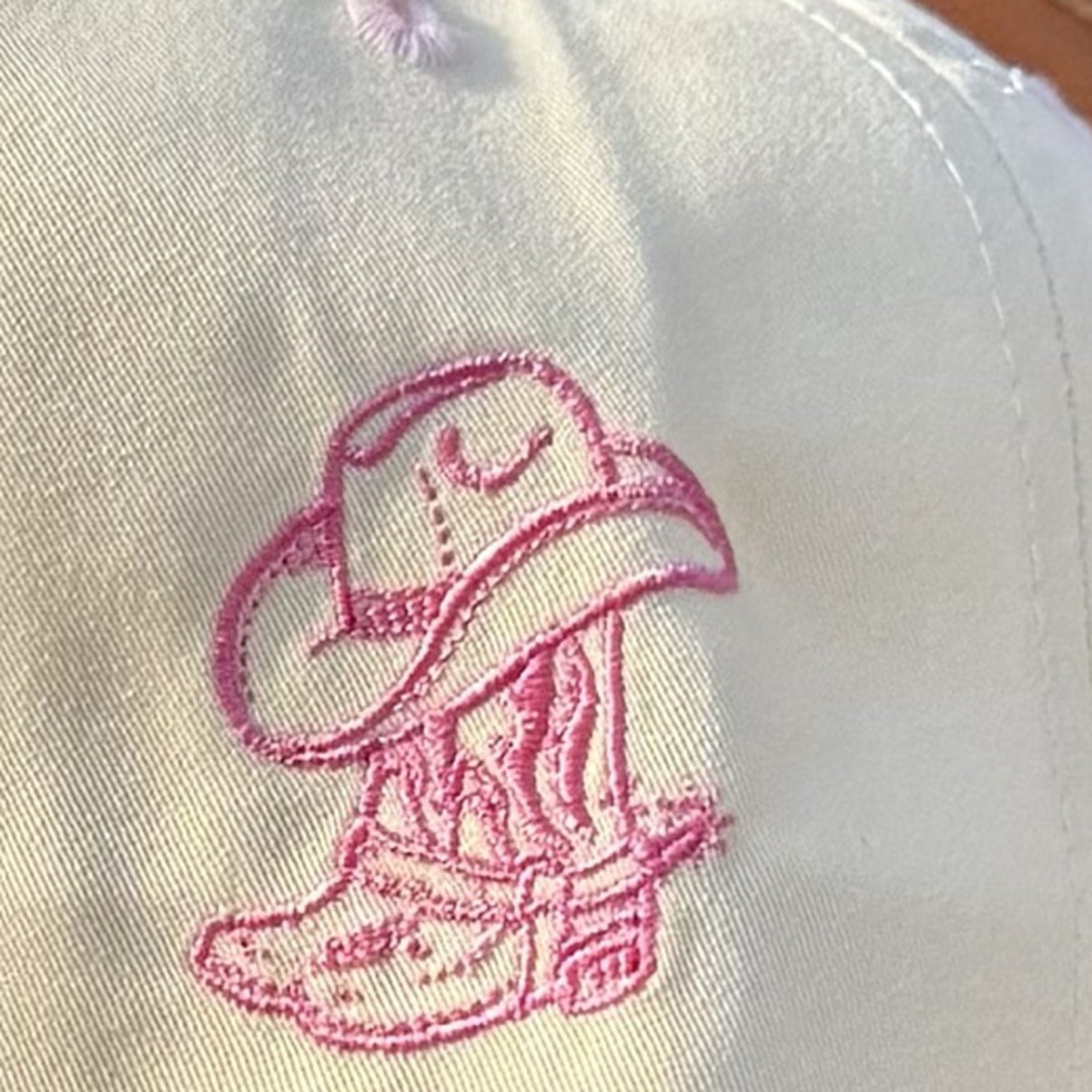 Close-up of the embroidered cowboy boot and hat on the side of the Take Me to the Rodeo trucker hat