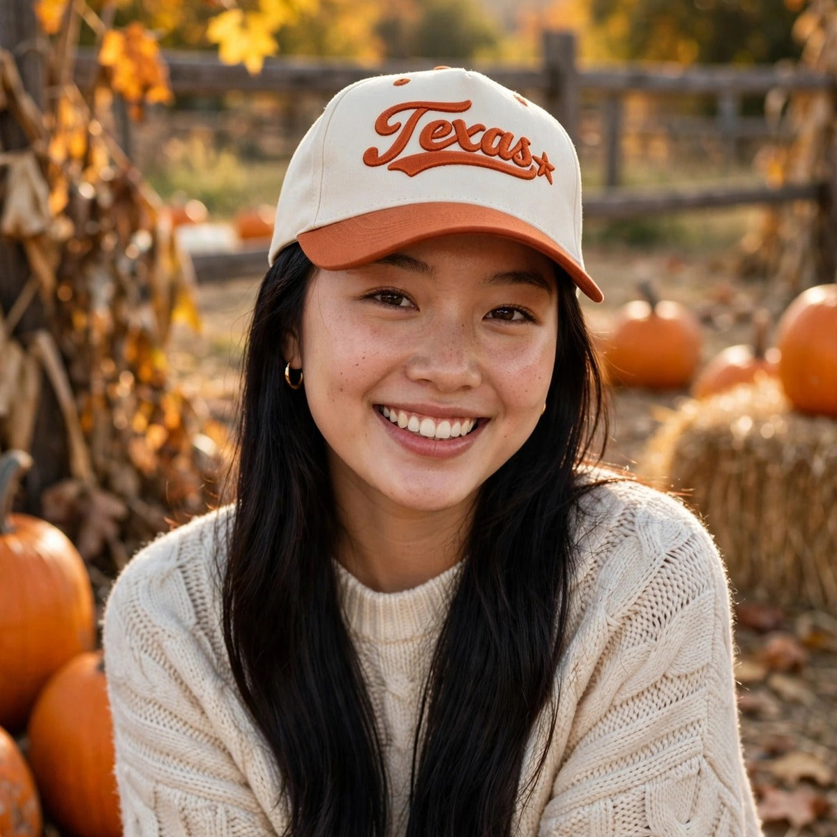 Woman at a fall pumpkin patch wearing the Texas 3D Star trucker hat in Natural / Orange Bill with matching orange embroidery