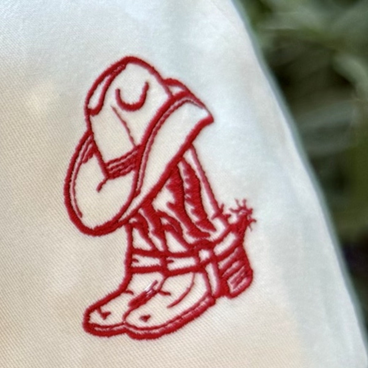 Close-up of the embroidered cowboy boot and hat on the side of the Vaquera trucker hat