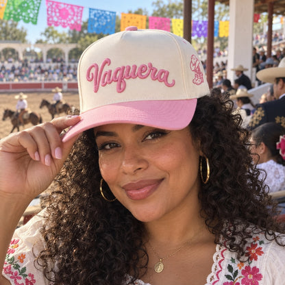 Woman in a charreada grandstand wearing the Vaquera trucker hat in Natural / Pink Bill with pink embroidery