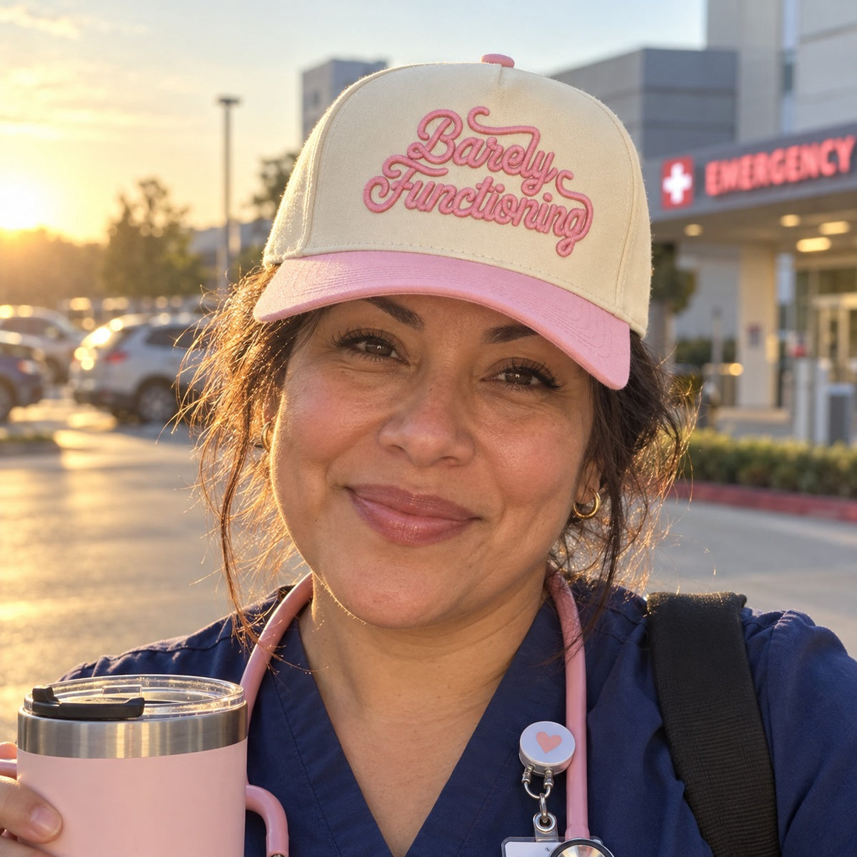 Nurse in scrubs after a night shift wearing the Barely Functioning trucker hat in Natural / Pink Bill with pink embroidery