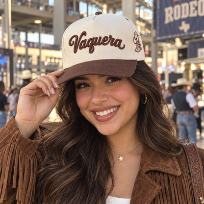 Young woman on a rodeo concourse wearing the Vaquera trucker hat in Natural / Brown Bill with brown embroidery