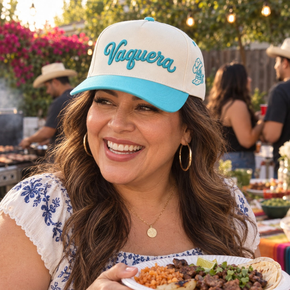 Woman at a backyard carne asada wearing the Vaquera trucker hat in Natural / Aqua Bill with aqua embroidery