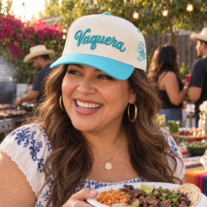Woman at a backyard carne asada wearing the Vaquera trucker hat in Natural / Aqua Bill with aqua embroidery