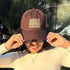 Woman wearing a brown baseball hat embroidered with Always Chingona Sometimes Cabrona Baseball hat