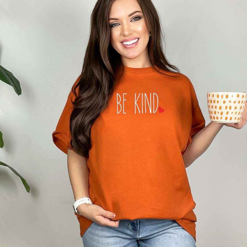 Female wearing a orange oversized unisex t-shirt embroidered with Be Kind and a heart - DSY Lifestyle