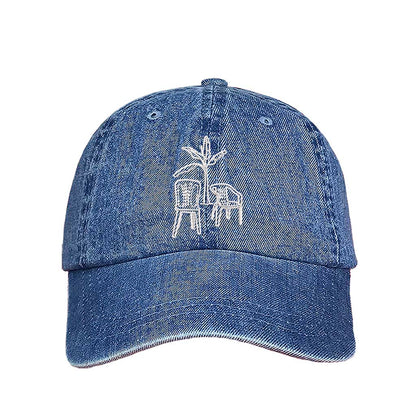 Front the DTMF Debi Tirar Mas Fotos denim dad cap featuring an embroidered banana tree with two chairs, inspired by Bad Bunny&