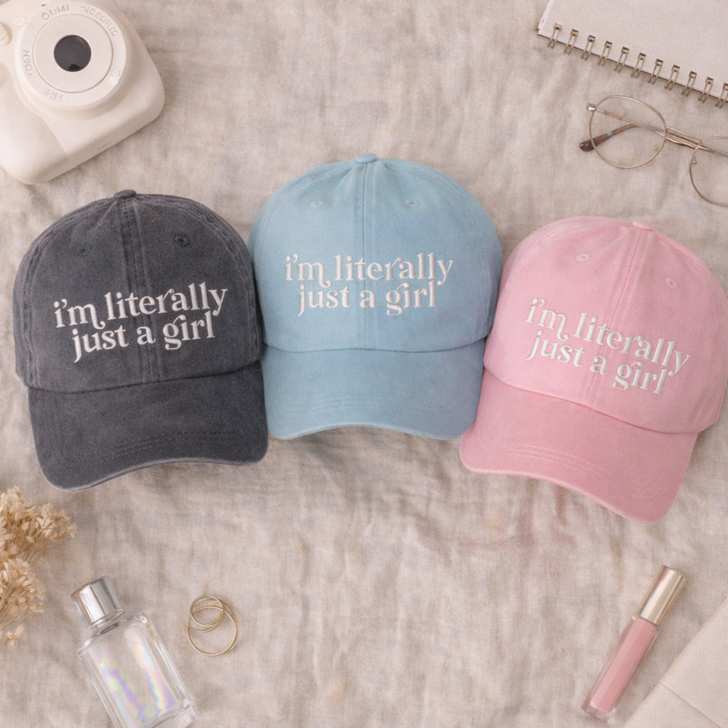 Flat lay of Gray, Light Blue, and Pink I’m Literally Just A Girl washed cotton baseball hats with a soft finish and high-density white embroidery by DSY Lifestyle. - DSY Lifestyle