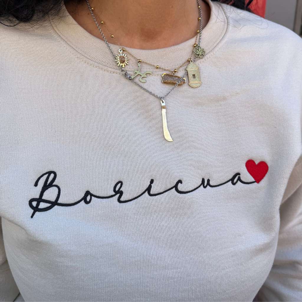 Close up of the black embroidered Boricua Stone Sweatshirt with a DTMF Bad Bunny Inspired Baseball Hat = DSY Lifestyle