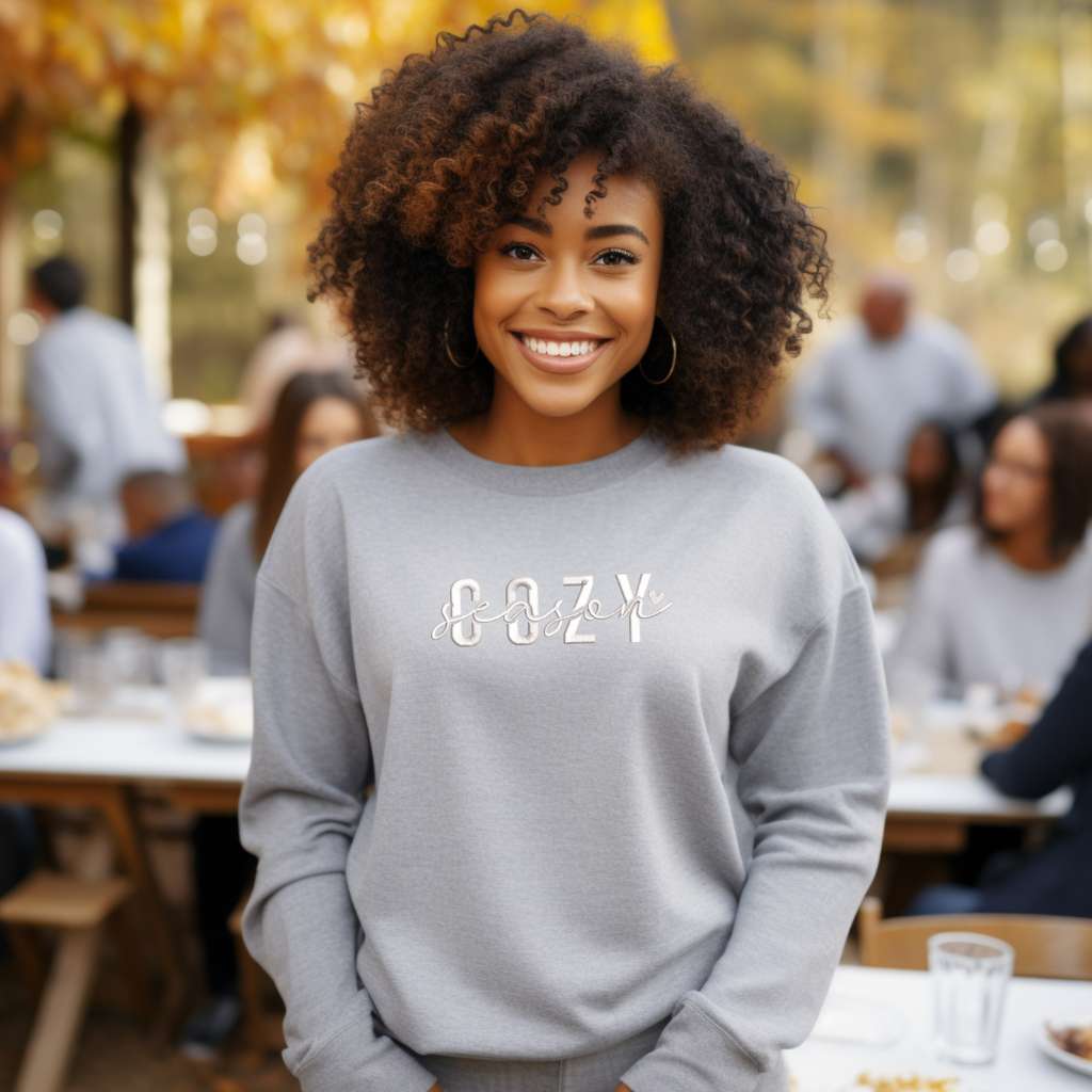 Female wearing a heather gray crewneck sweatshirt embroidered with Cozy Season - DSY Lifestyle