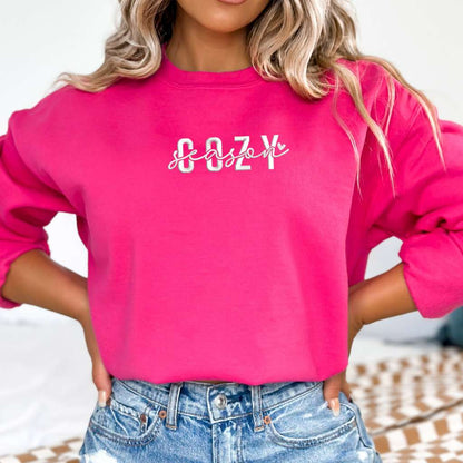 Female wearing a hot pink crewneck sweatshirt embroidered with Cozy Season - DSY Lifestyle
