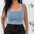 Woman in a soft blue square neck crop tank with black pants, styled for a casual-chic everyday look.

