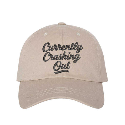 Stone with black thread Currently Crashing Out embroidered baseball hat. A statement baseball hat for women who love humor, comfort, and effortless everyday outfits. - DSY Lifestyle